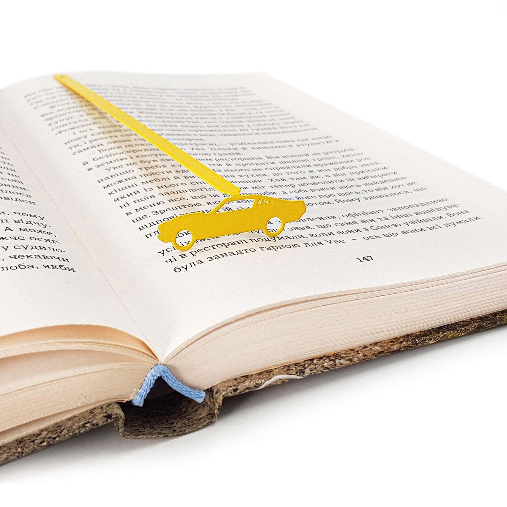 Yellow Muscle Car metal bookmark in gold set into the gutter of an open book