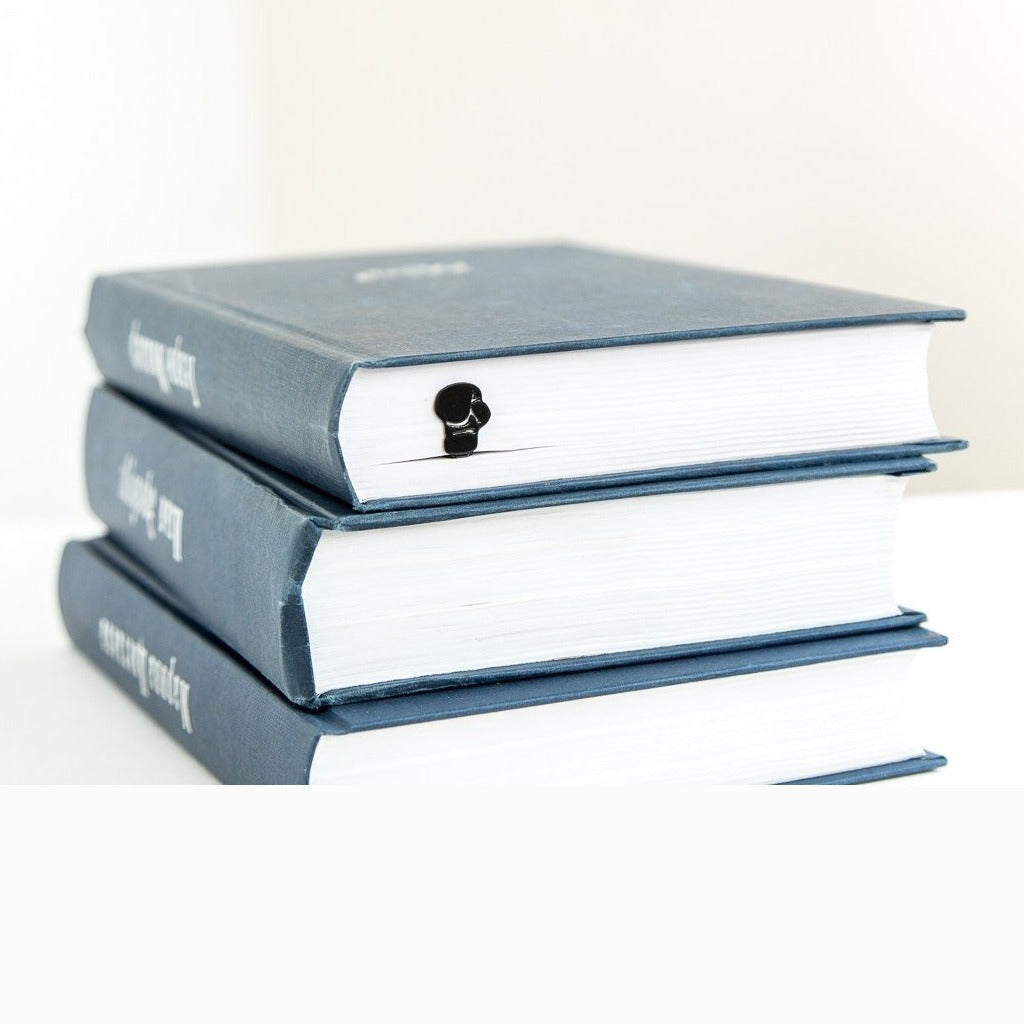 Boxing Glove metal bookmark shown with a stack of books