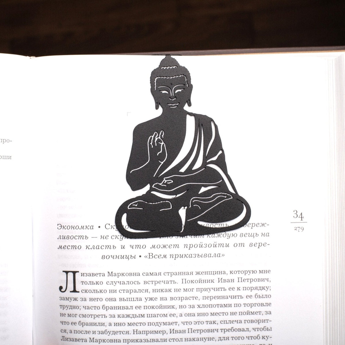Buddha metal bookmark resting on the pages of an open book