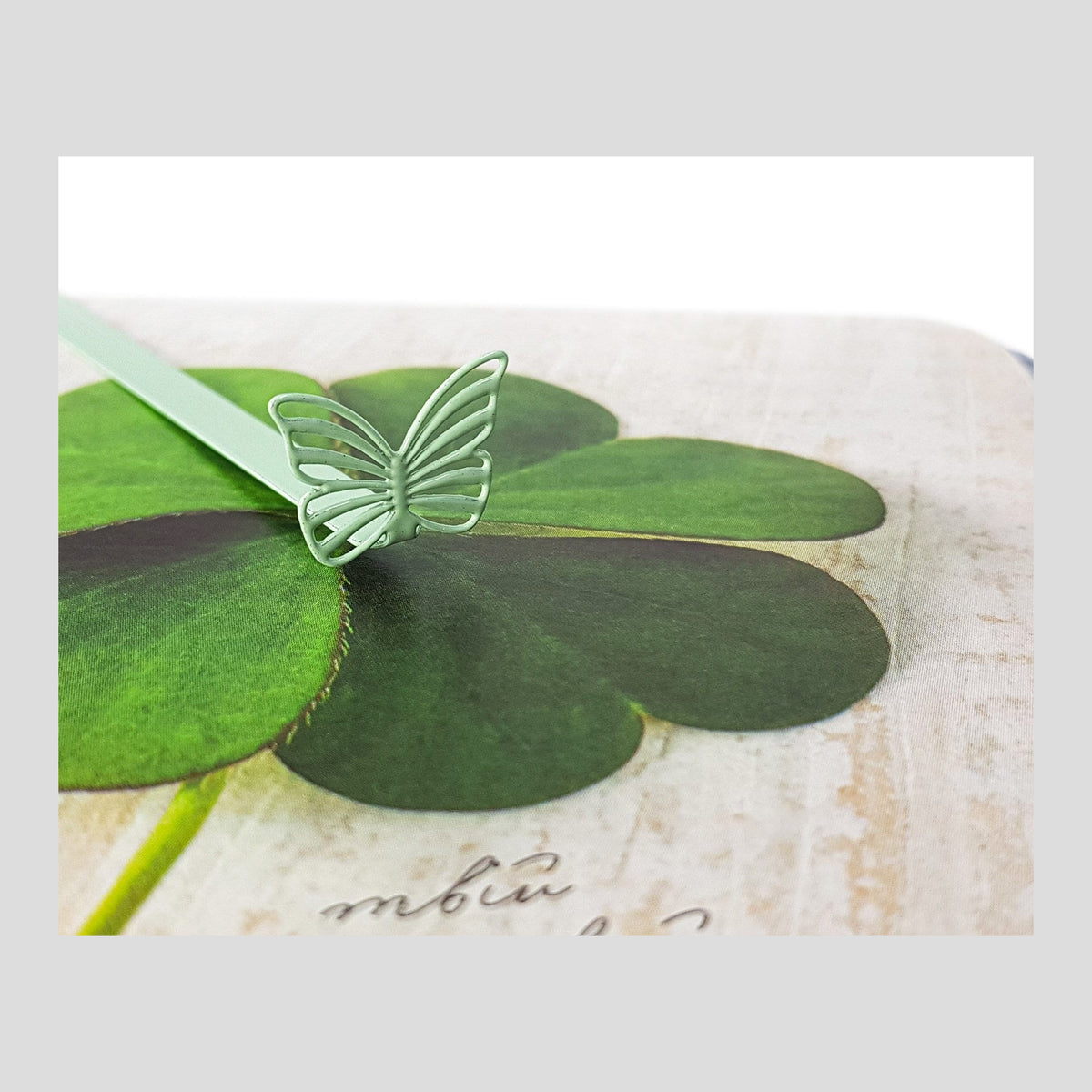 Butterfly metal bookmark in green on a coloured background