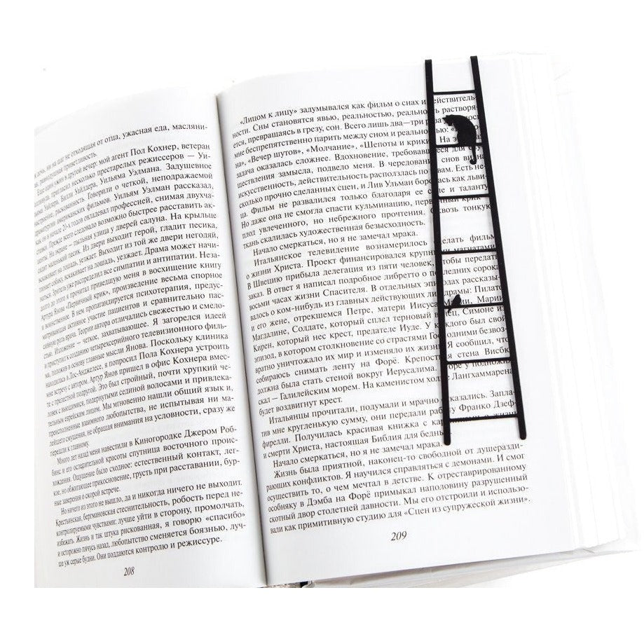 Cat and Bird on the Ladder metal bookmark resting on the pages of an open book