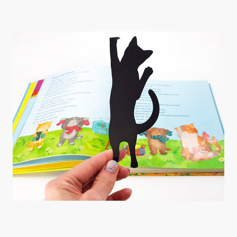 Cat Got Stuck metal bookmark marking a page in an illustrated book