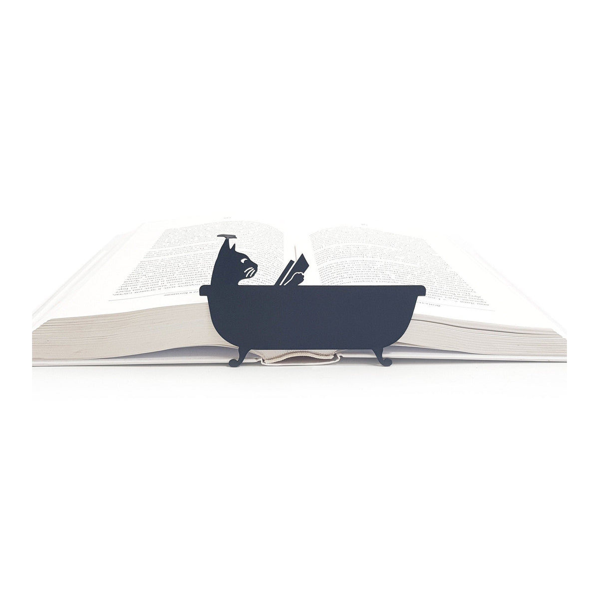 Cat Reading in the Tub metal bookmark resting on the pages of an open book