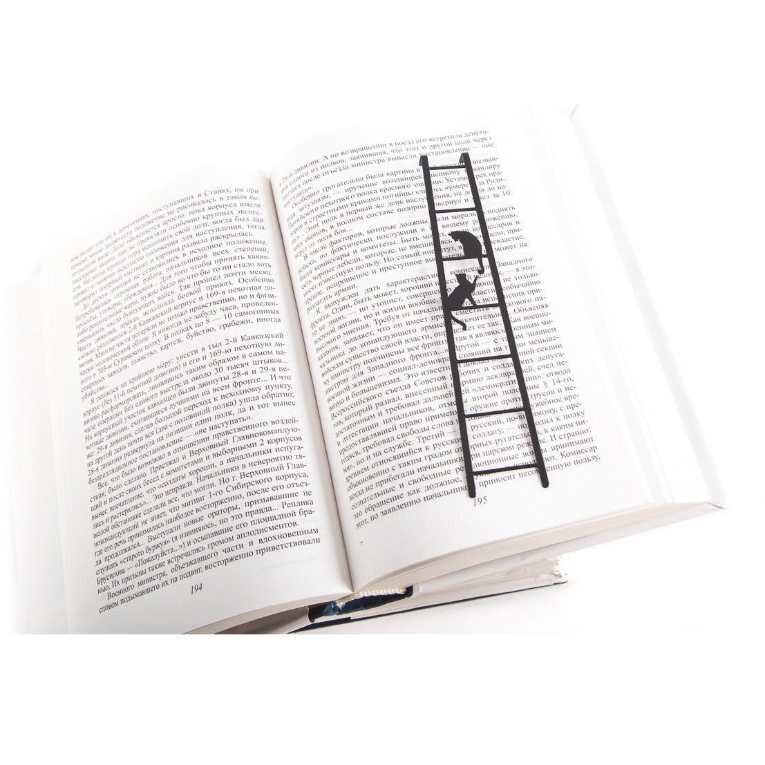 Cats on the Ladder metal bookmark resting on the pages of an open book