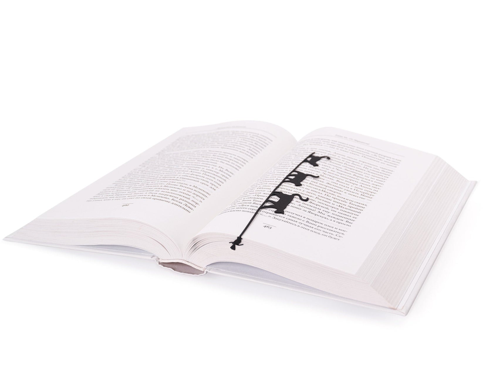 Cats Tightrope Walkers metal bookmark marking a page in an open book