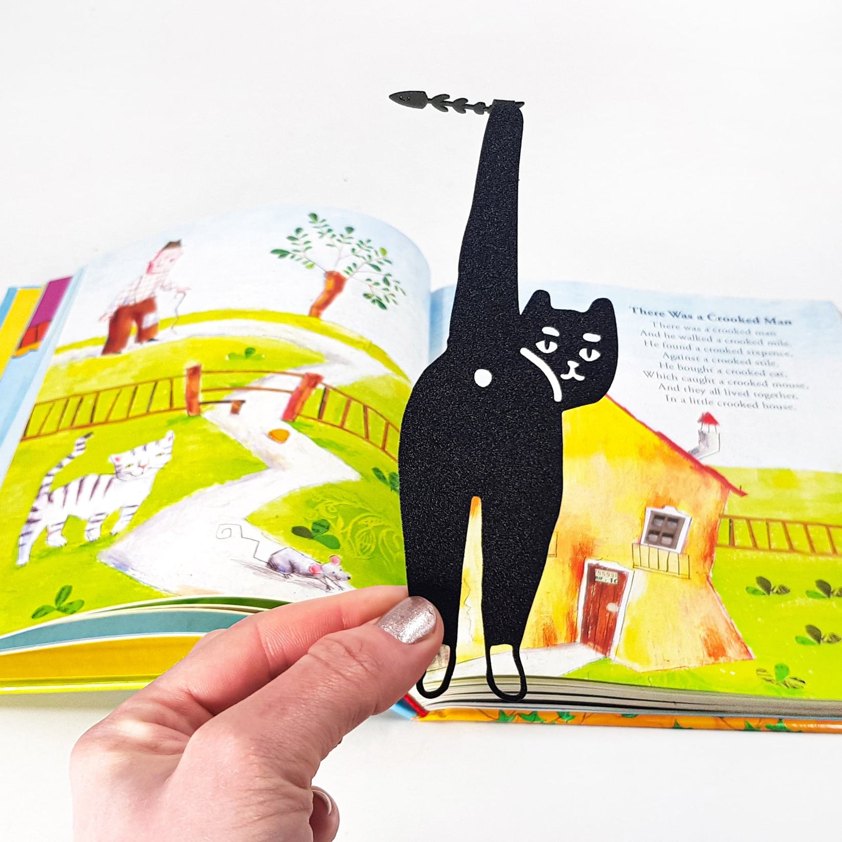 Cheeky Black Cat book marker marking a page in an illustrated book
