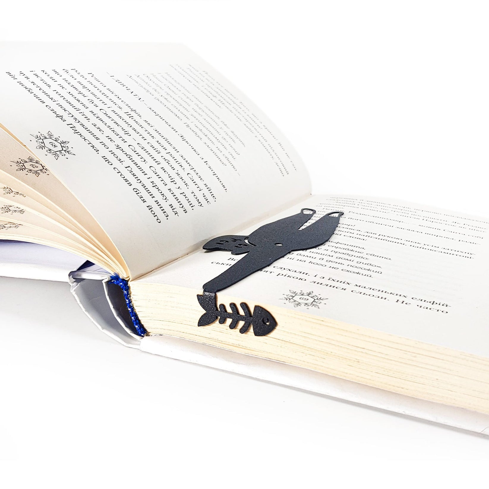 Cheeky Black Cat book marker marking a page in an open book