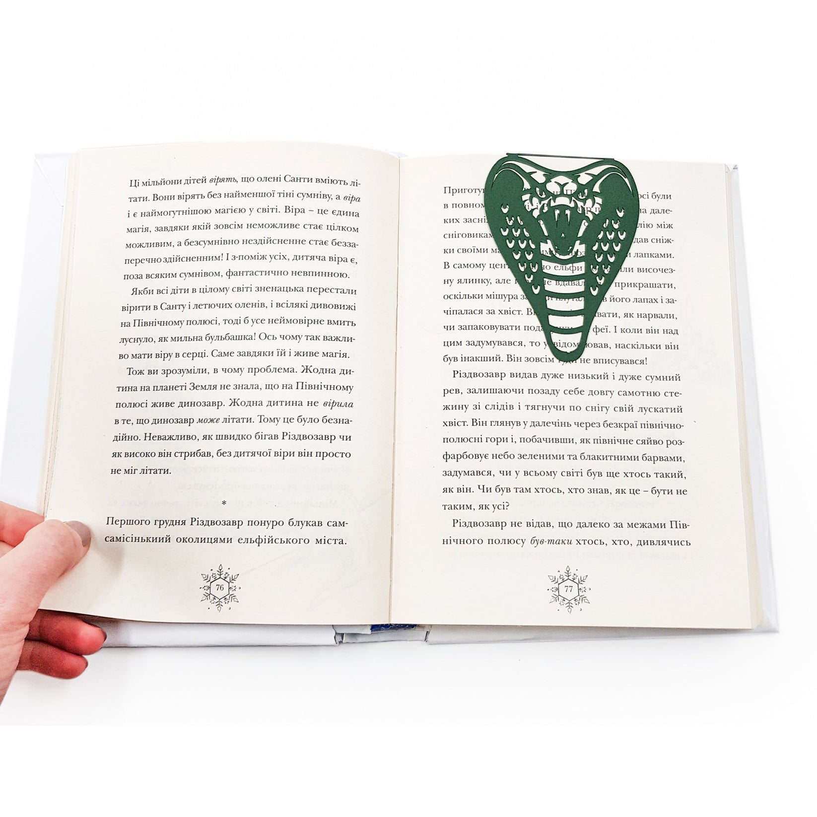Cobra metal bookmark in green marking a page in an open book