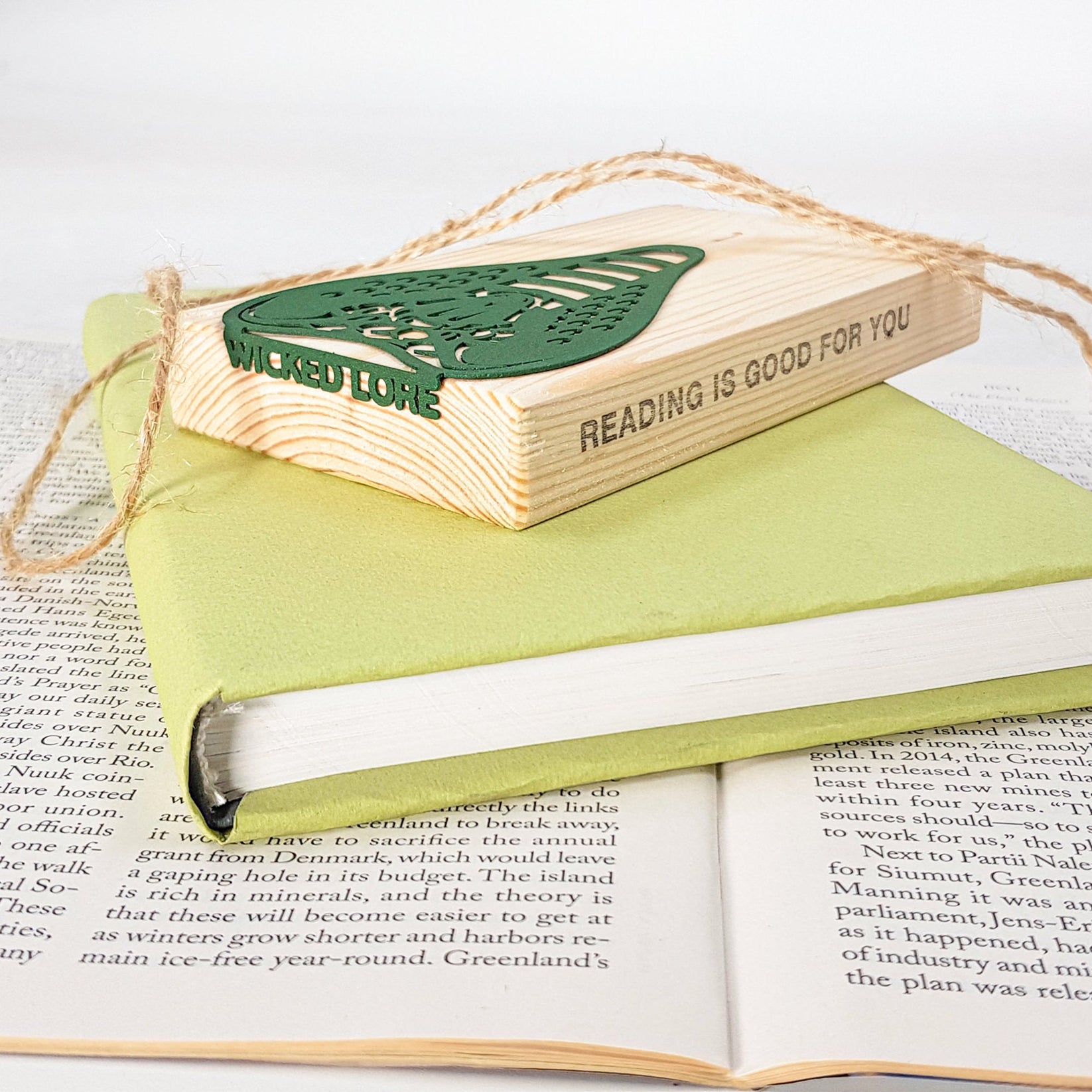 Cobra metal bookmark in green shown with a stack of books