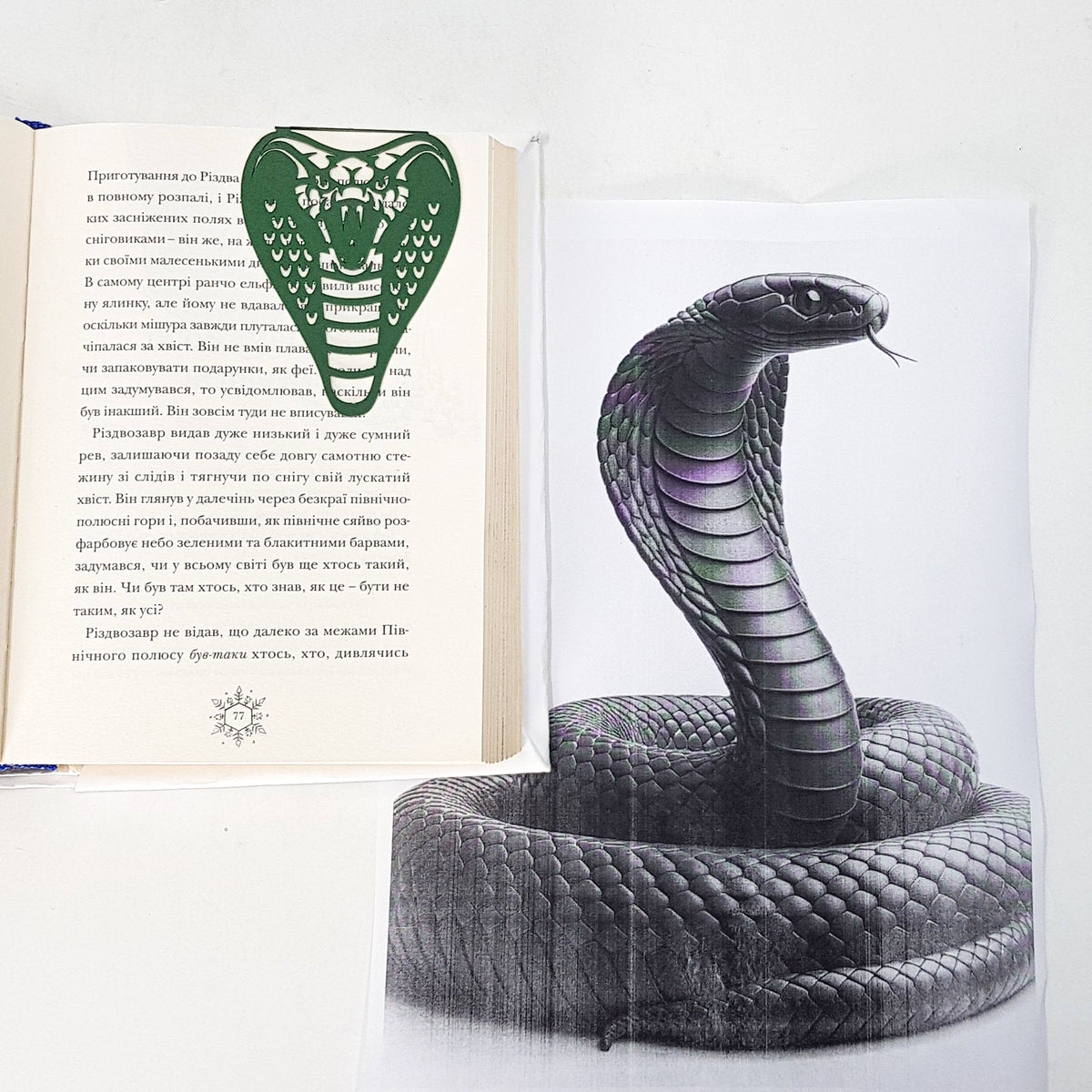 Cobra metal bookmark resting on the pages of an open book