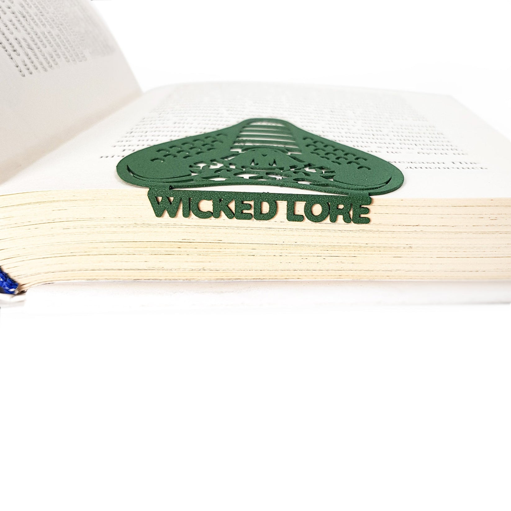 Cobra metal bookmark in green seen from the edge of a closed book