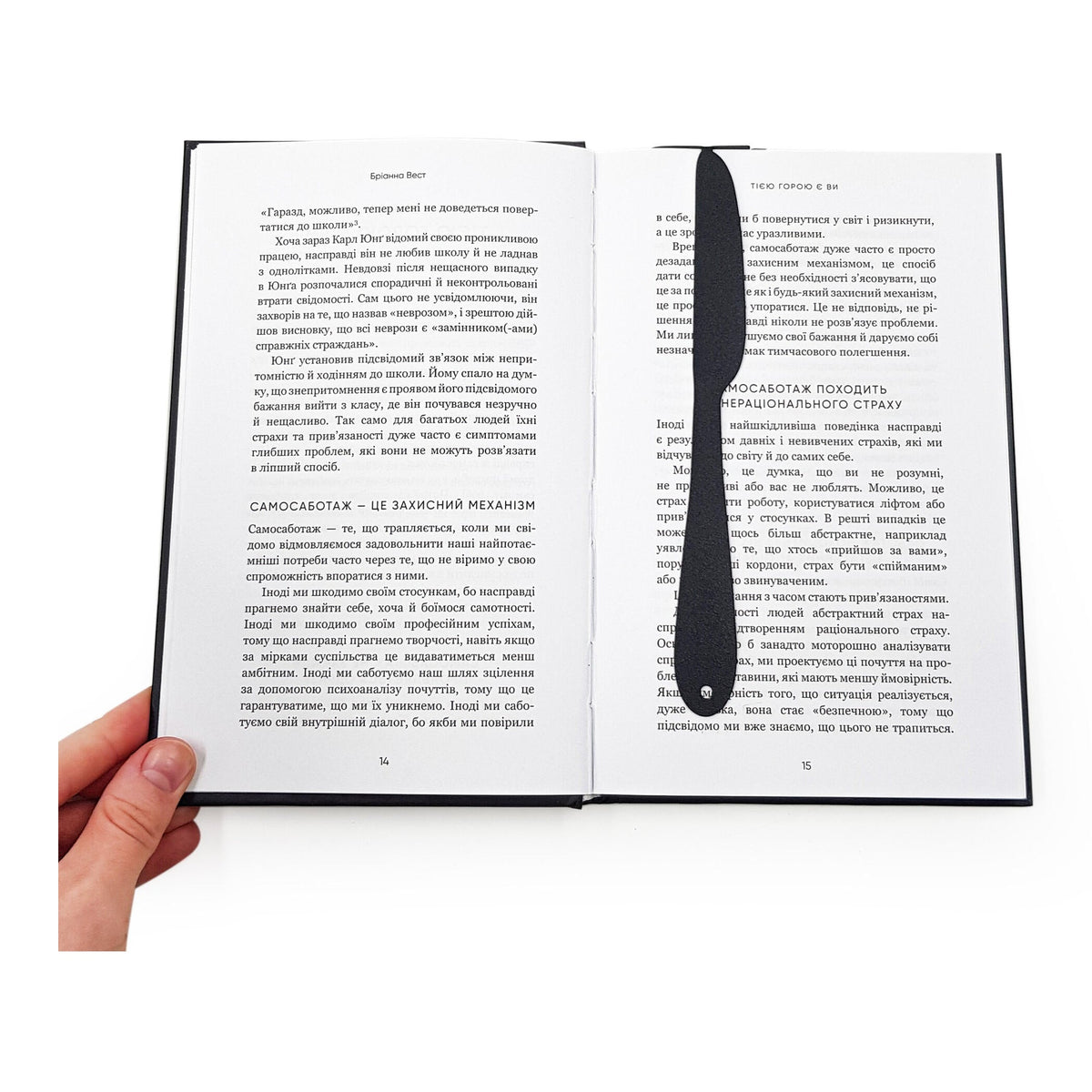 Knife-Shaped COOK metal bookmark resting on the pages of an open book