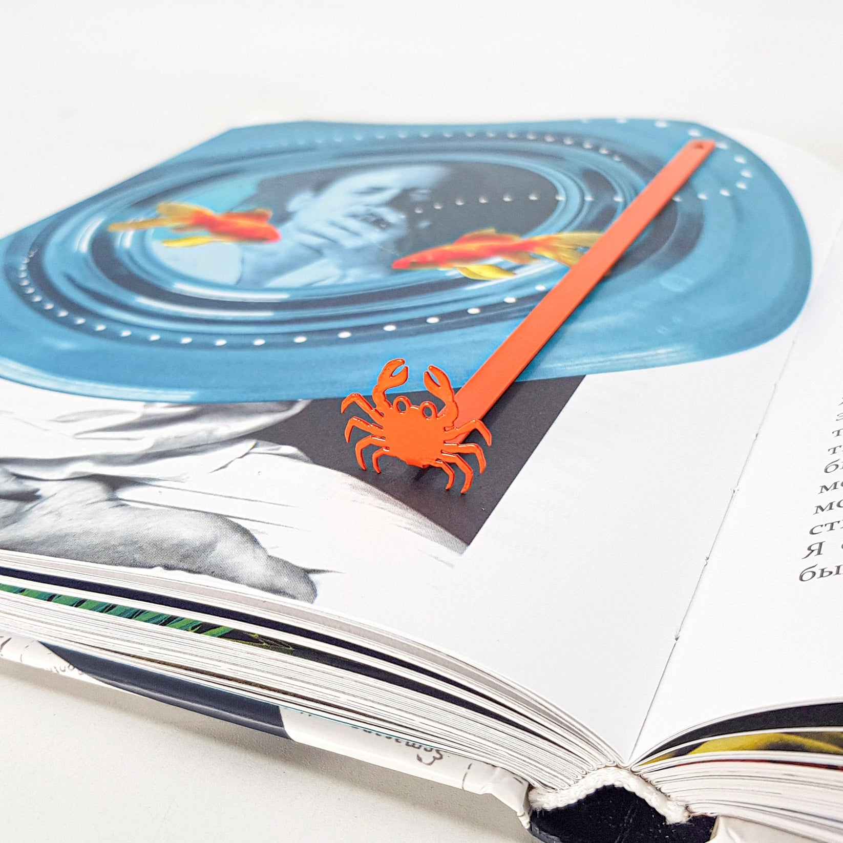Crab metal bookmark in red on an illustrated page
