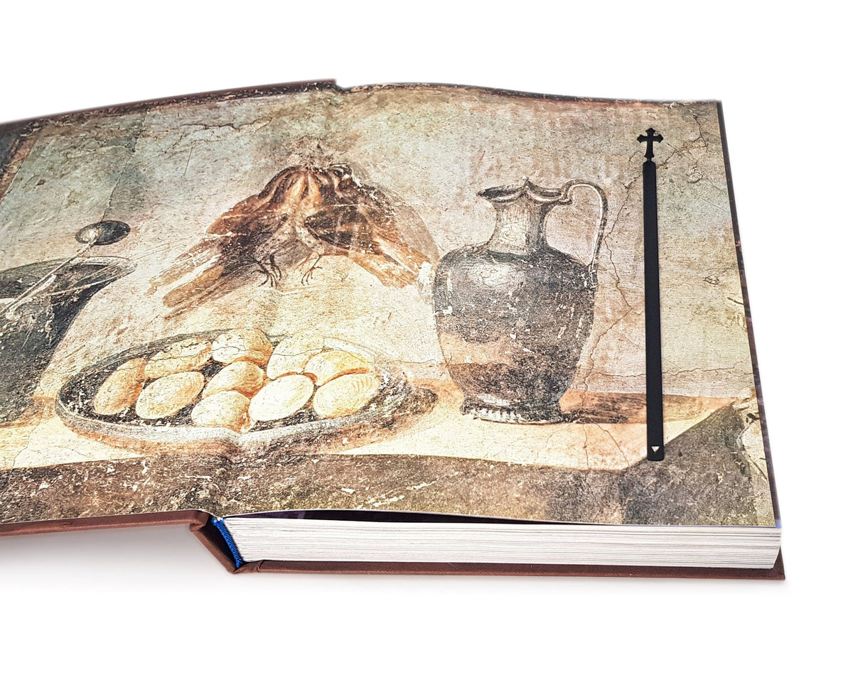 Cross metal bookmark on an illustrated page