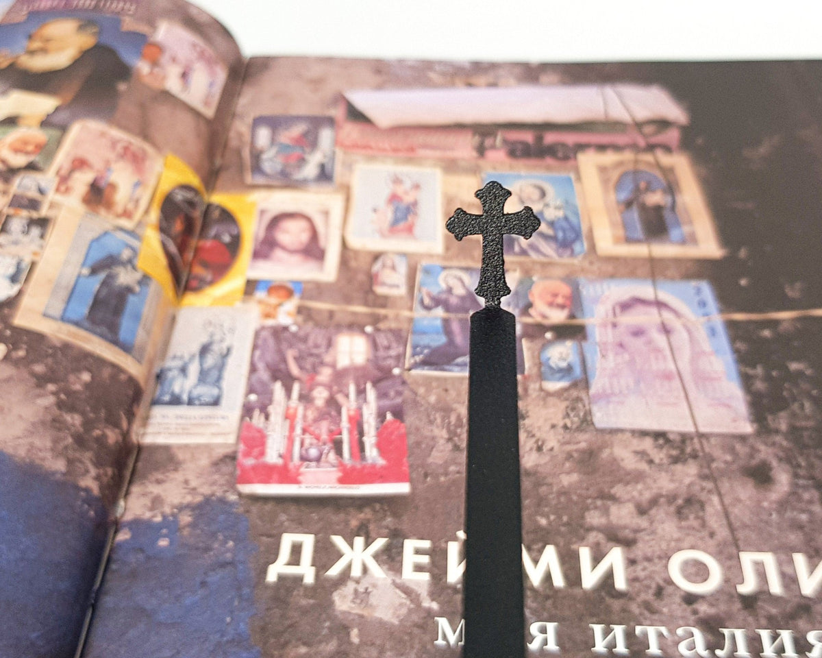 Cross metal bookmark on a coloured background