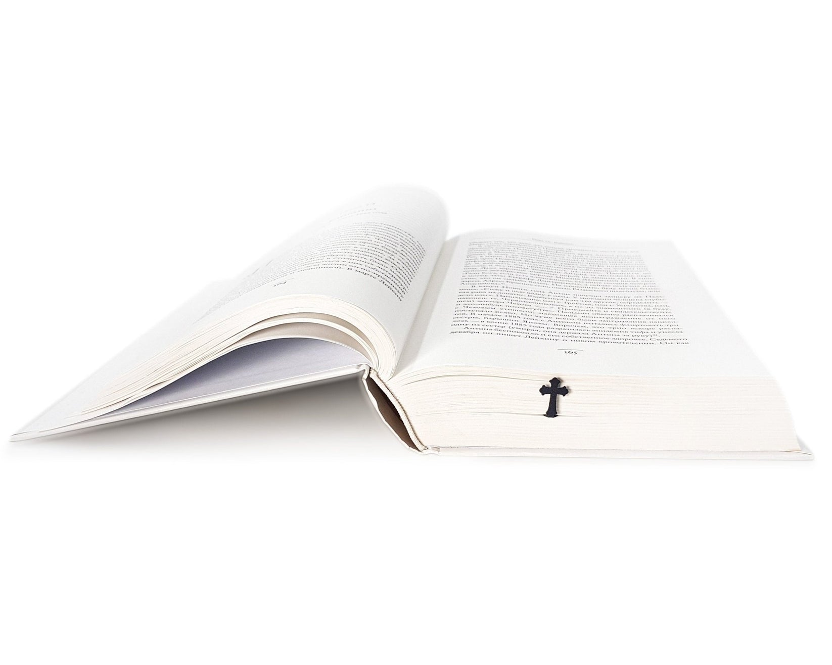 Cross metal bookmark lying across the pages of an open book
