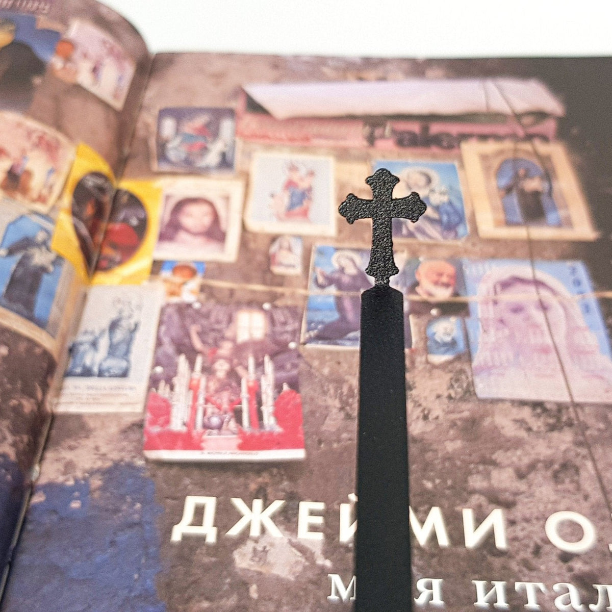 Cross metal bookmark on a coloured background