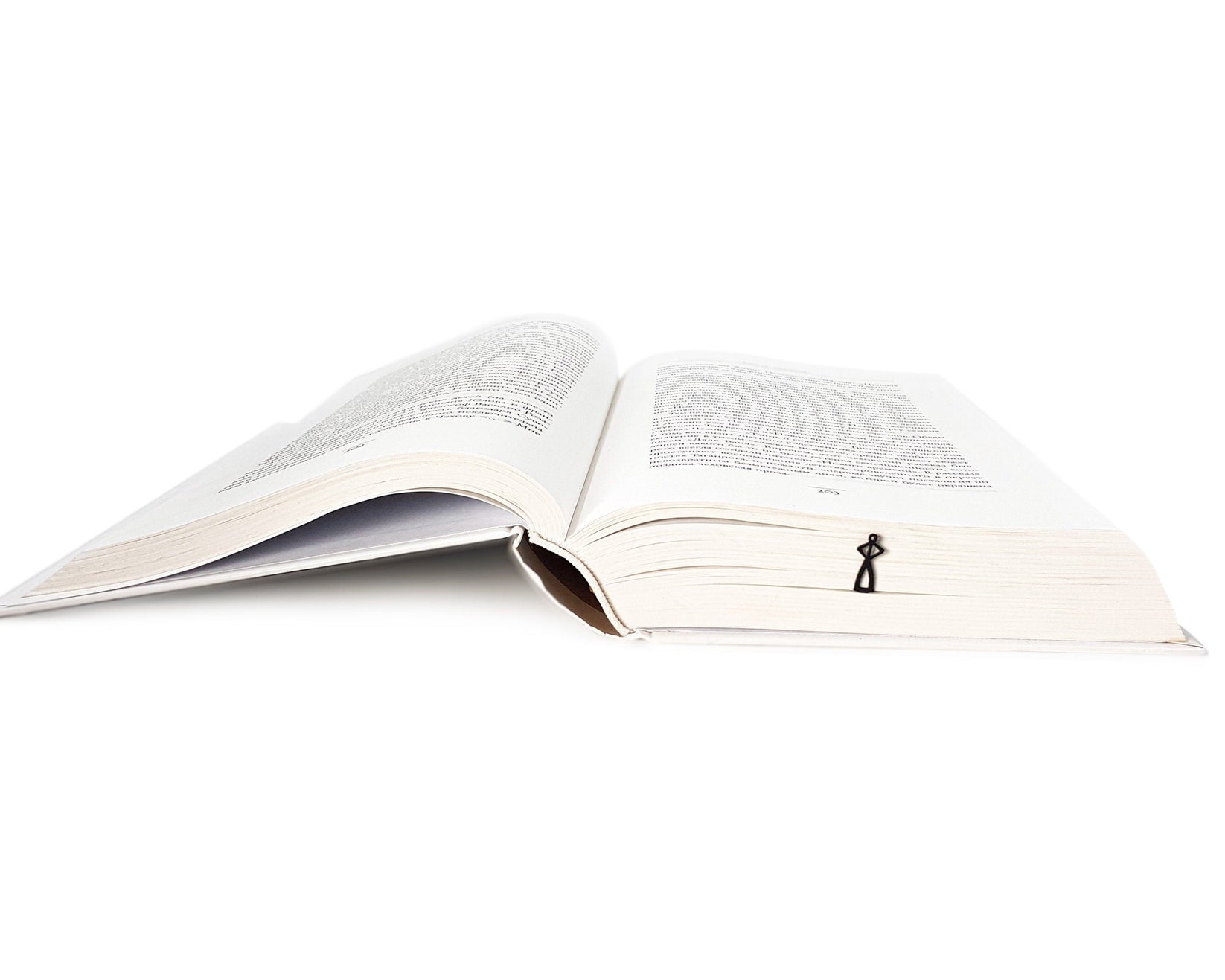 Black Stick Man metal bookmark lying across the pages of an open book