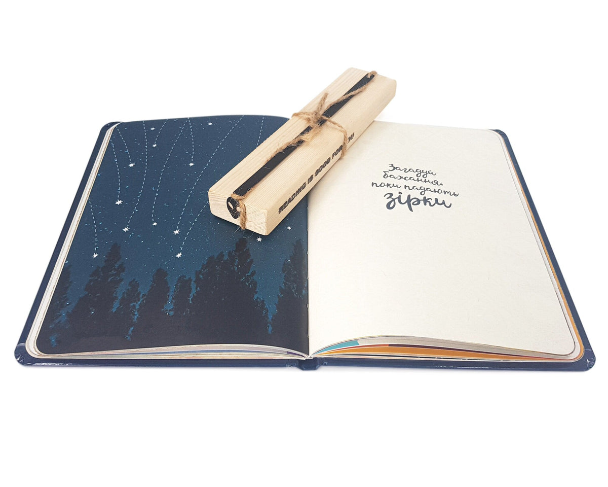 Alien Head metal bookmark marking a page in a notebook