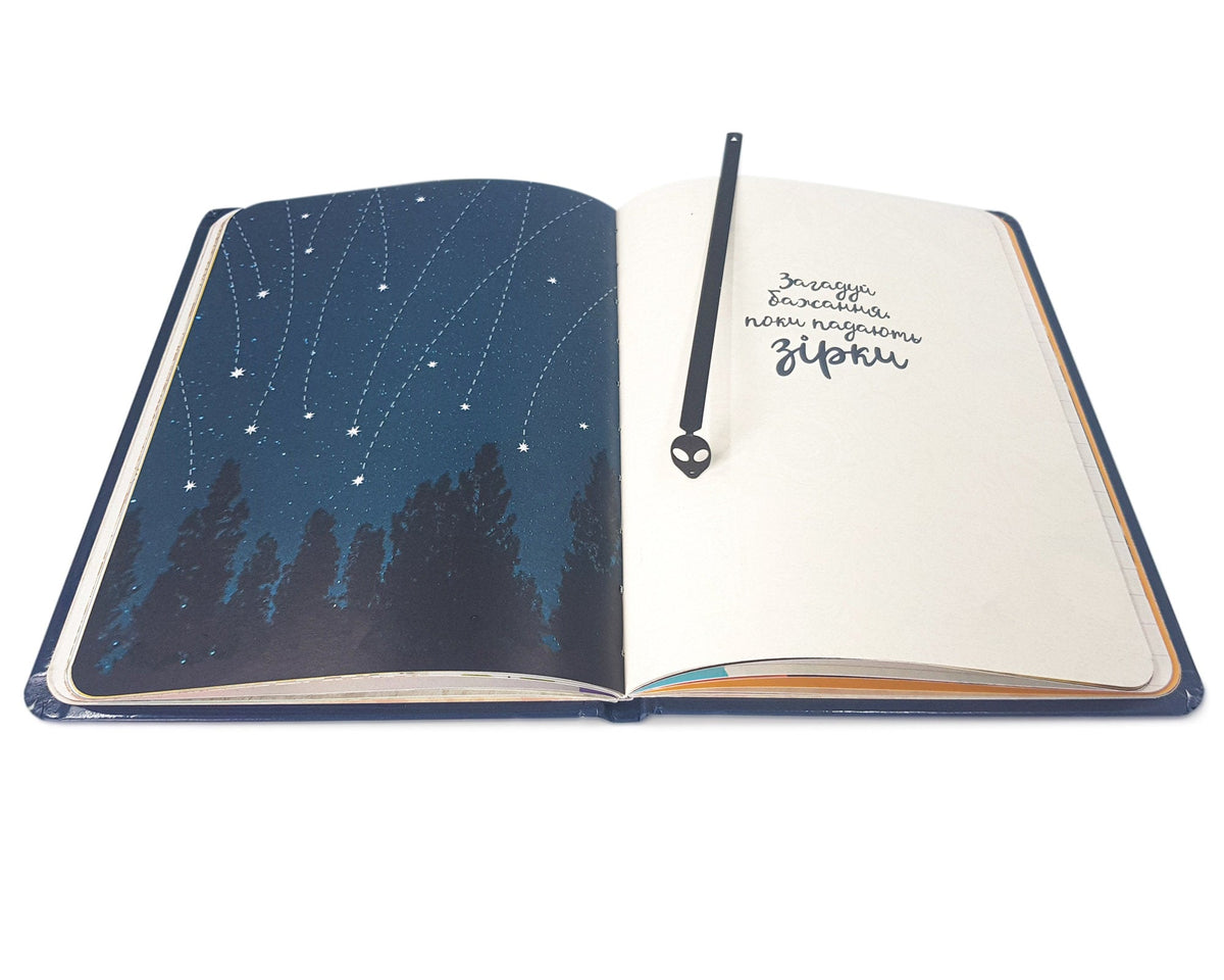 Alien Head metal bookmark tucked into a notebook