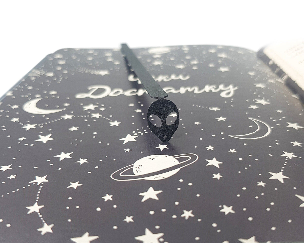 Alien Head metal bookmark against a coloured backdrop