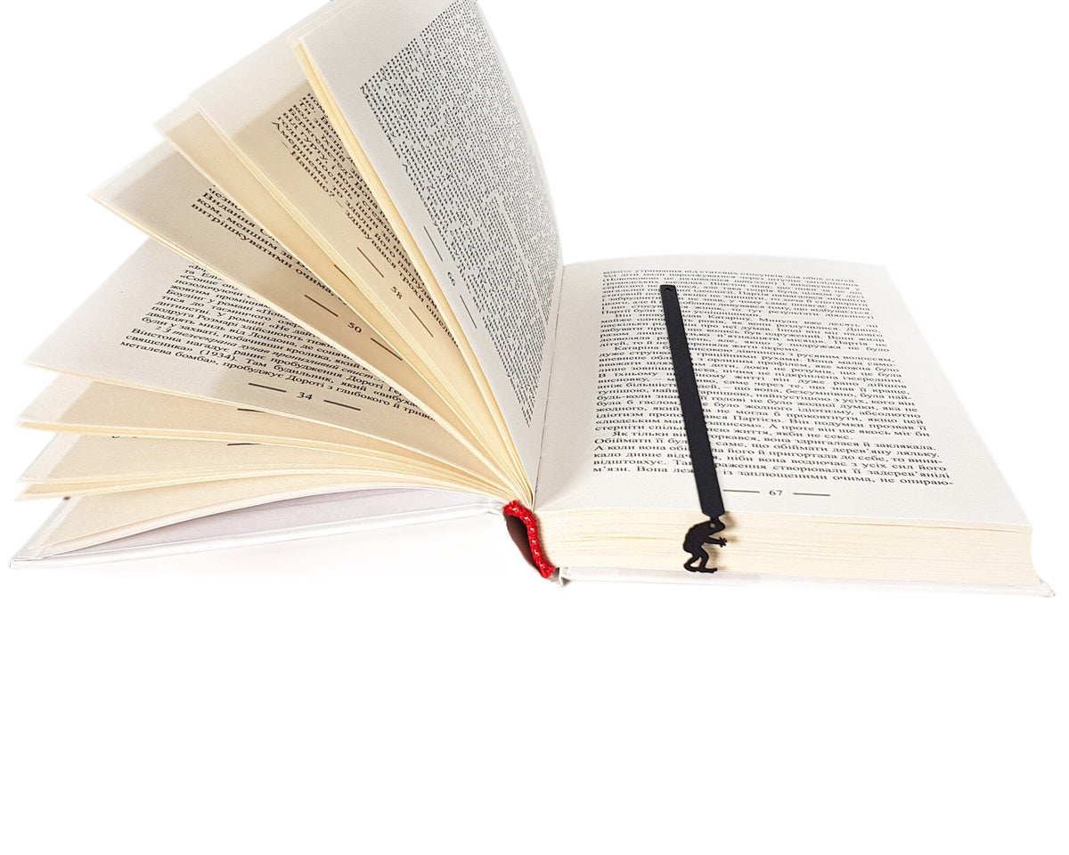 Frogman metal bookmark marking a page in an open book