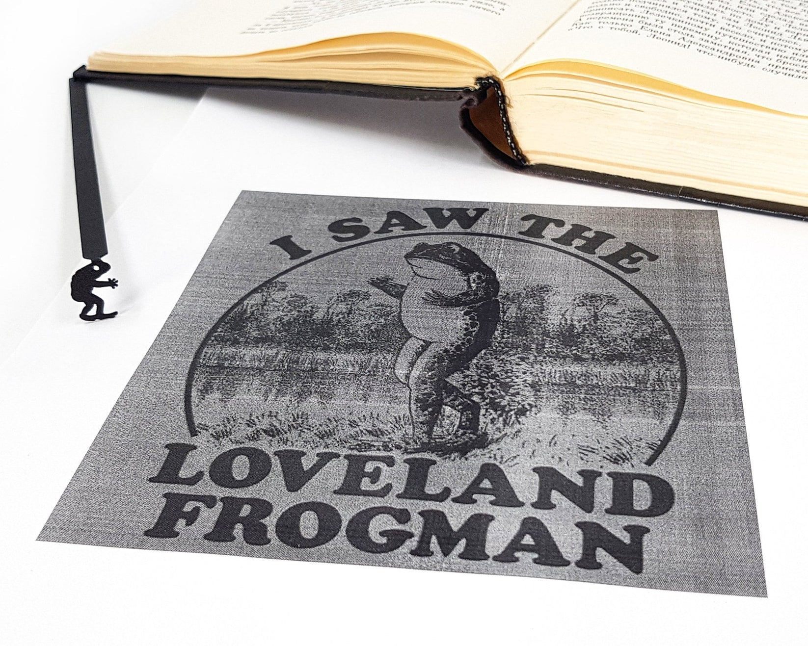 Frogman metal bookmark on an illustrated page