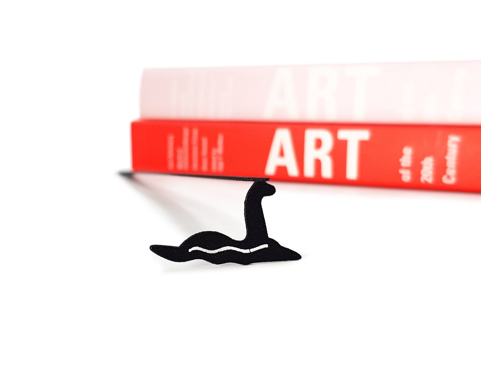 Loch Ness metal bookmark shown with a stack of books