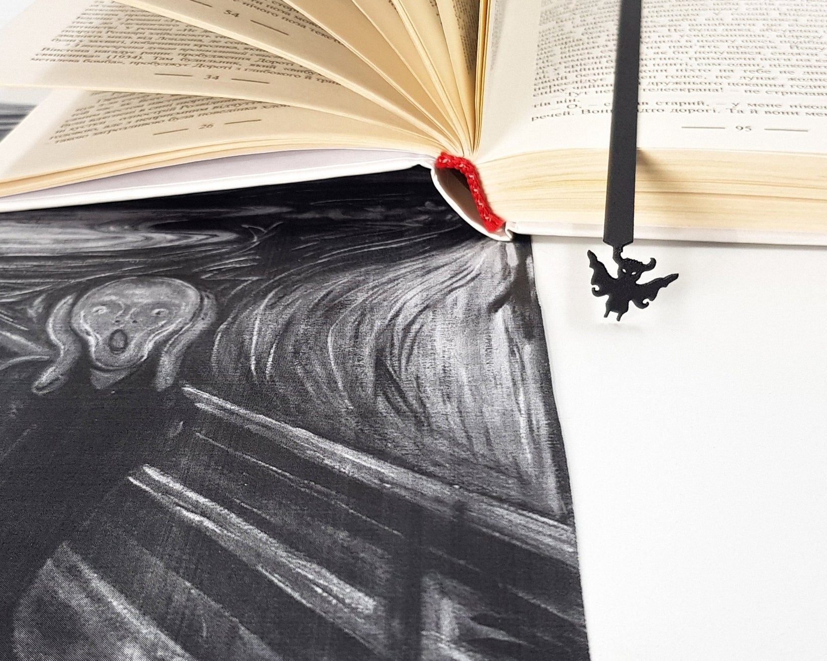 Monster Chupacabra metal bookmark marking a page in an illustrated book