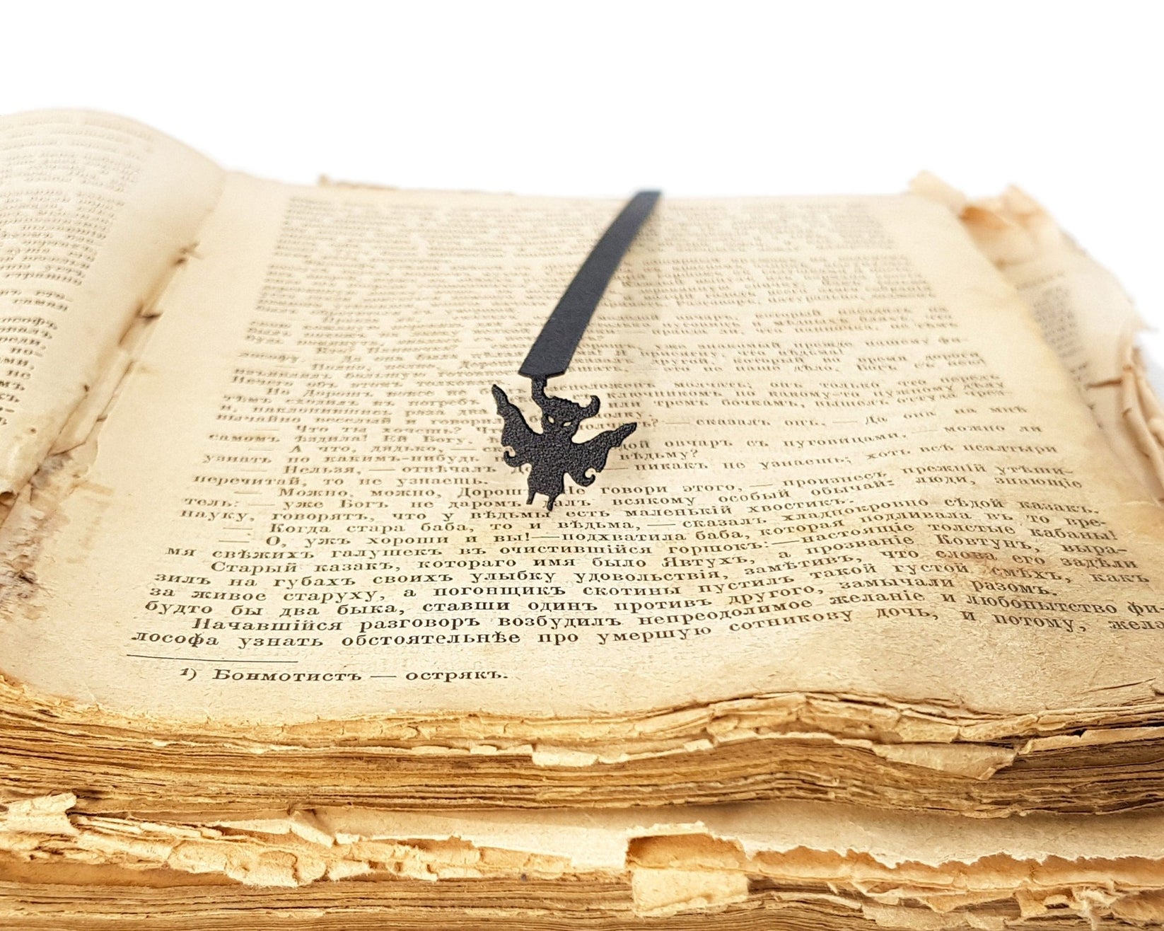 Monster Chupacabra metal bookmark resting on the pages of an open book