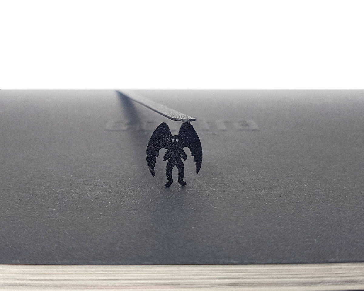 Mothman metal bookmark on a coloured background