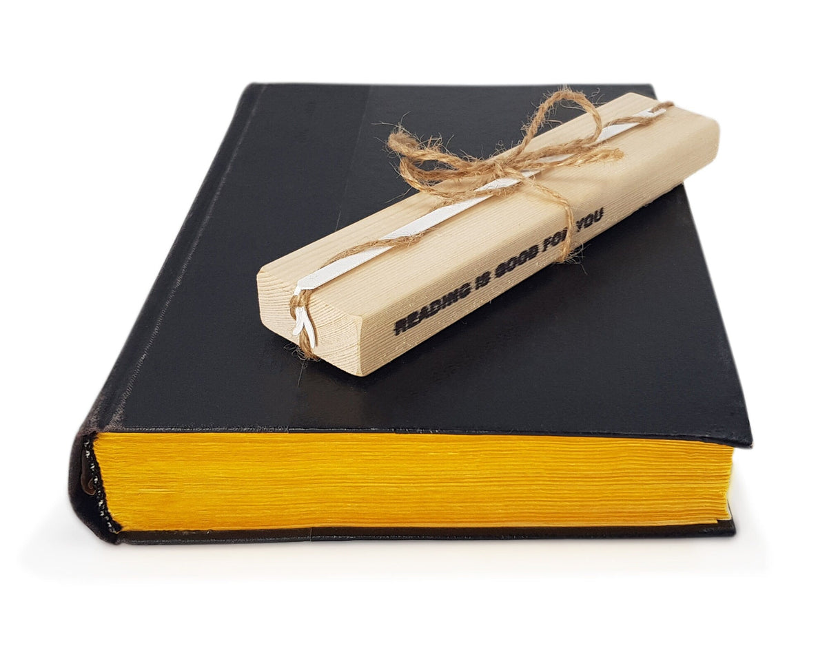 Nightcrawler metal bookmark in white seen from the edge of a closed book