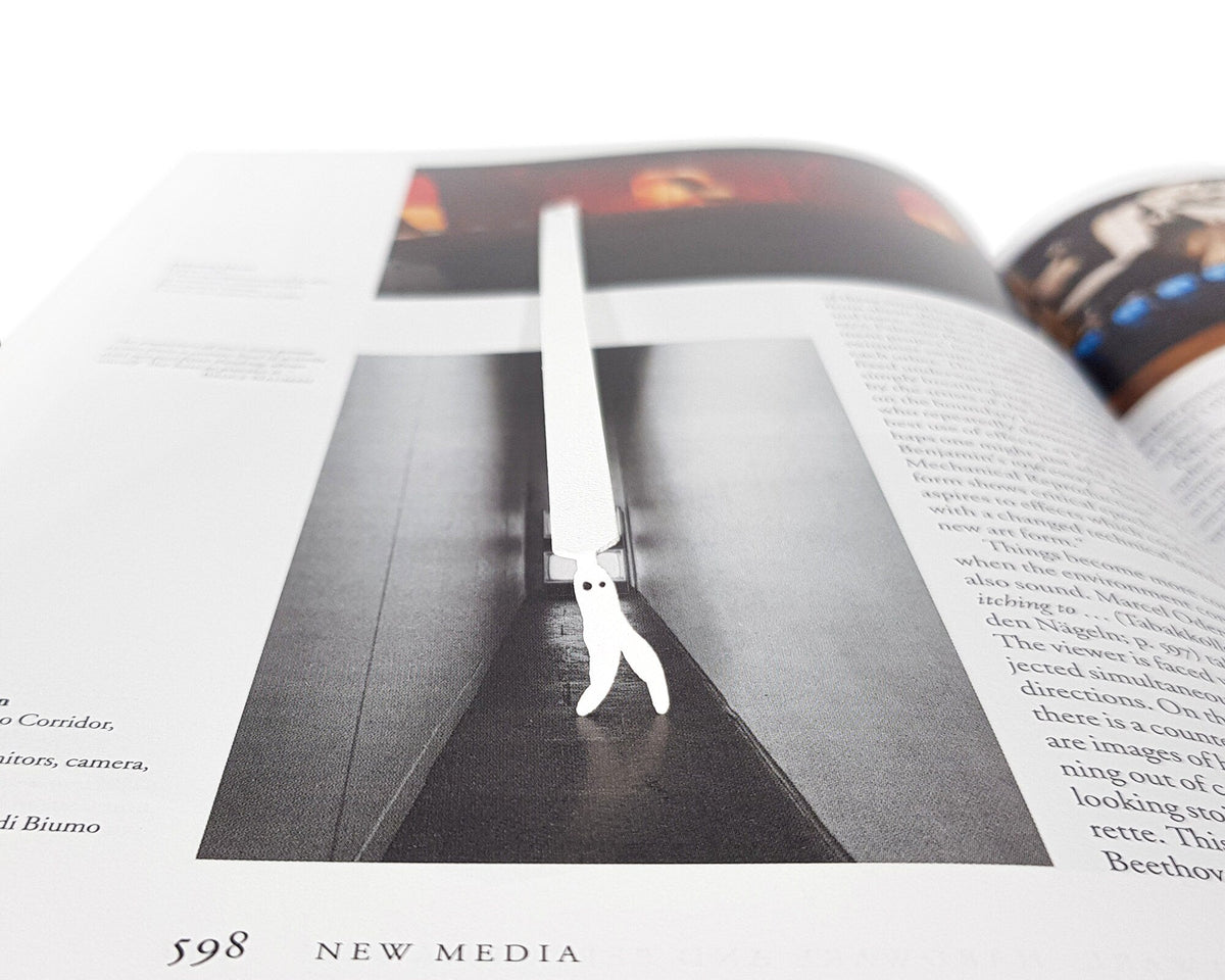 Nightcrawler metal bookmark in white placed on a colour illustration