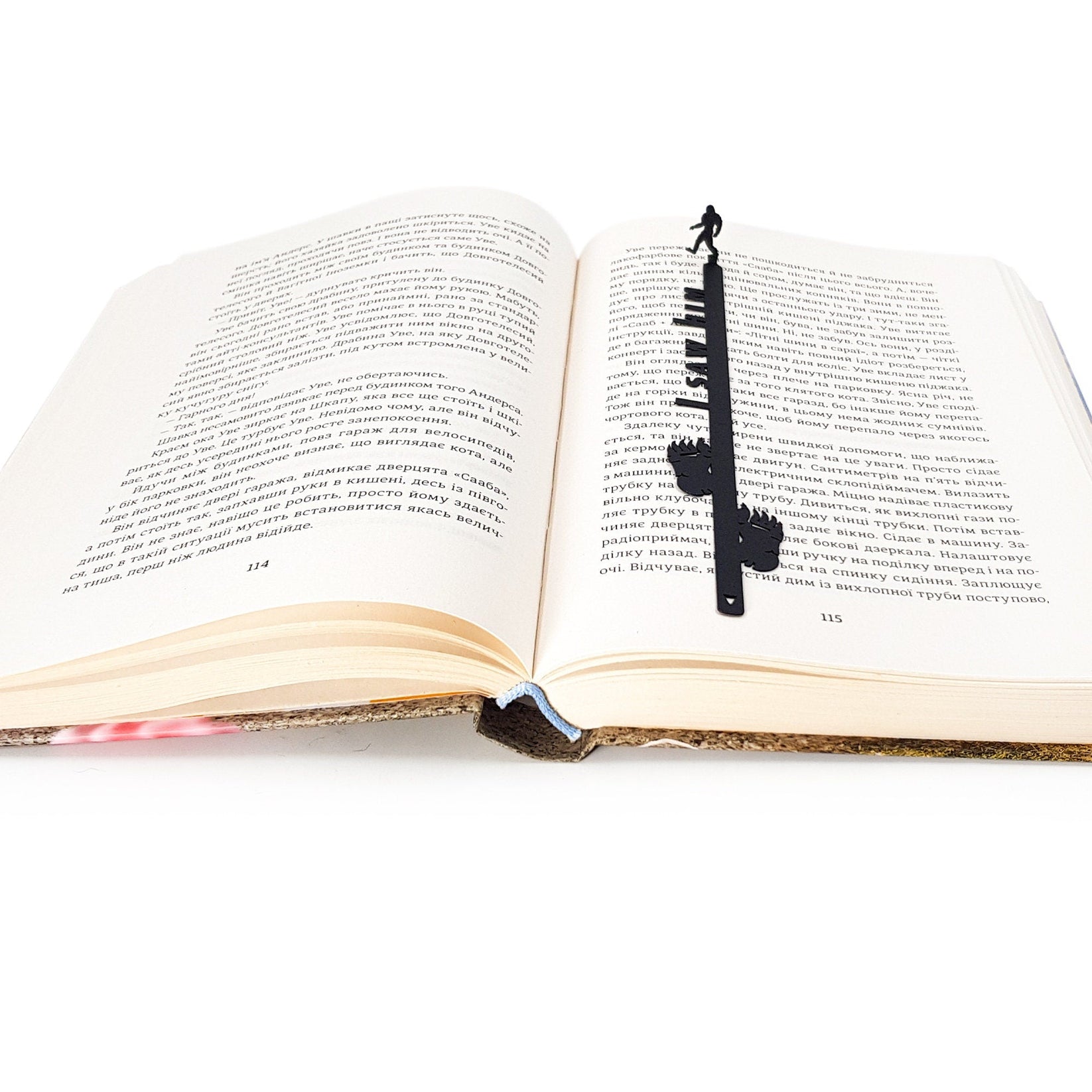 Bigfoot metal bookmark marking a page in an open book
