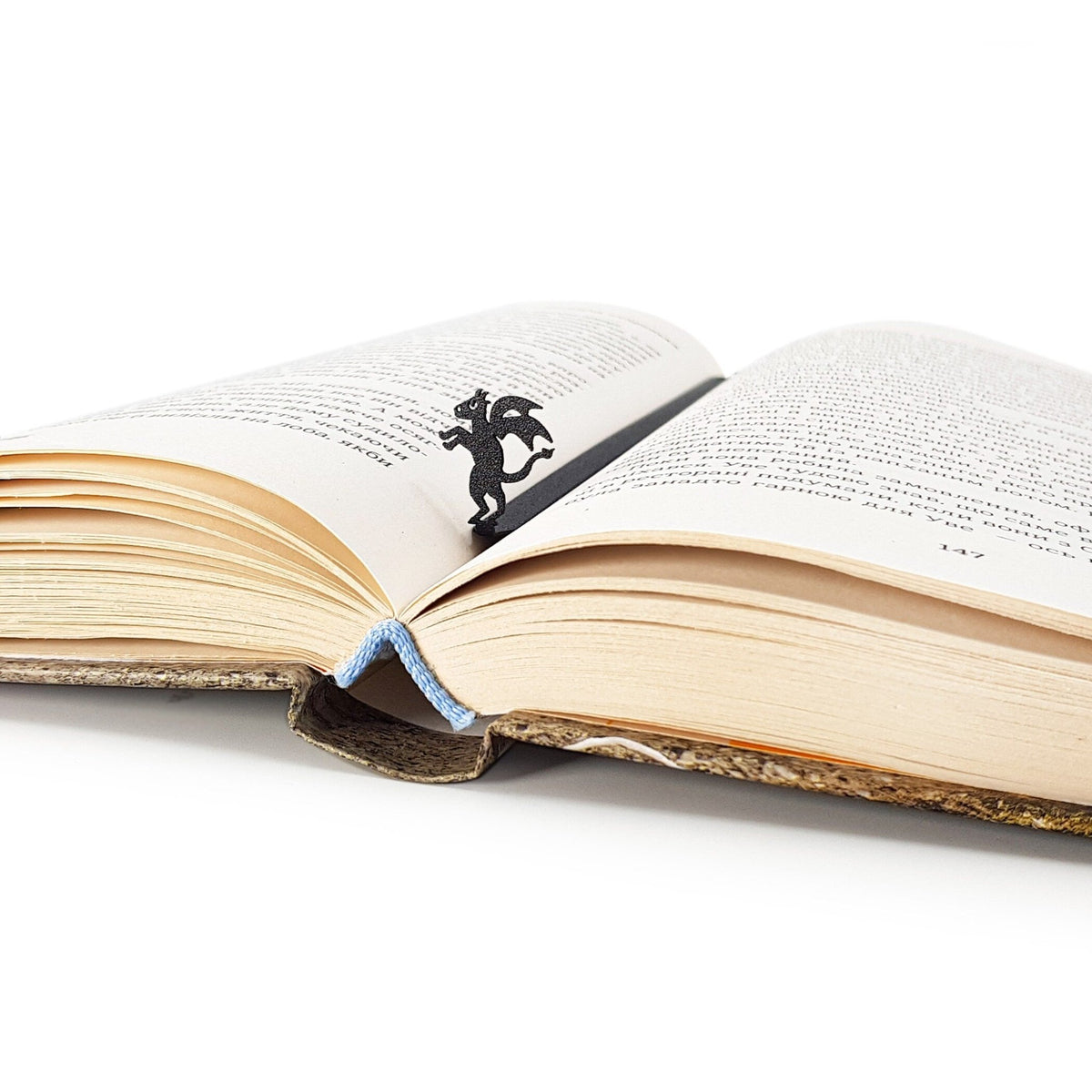 Monster Jersey Devil metal bookmark resting on the pages of an open book
