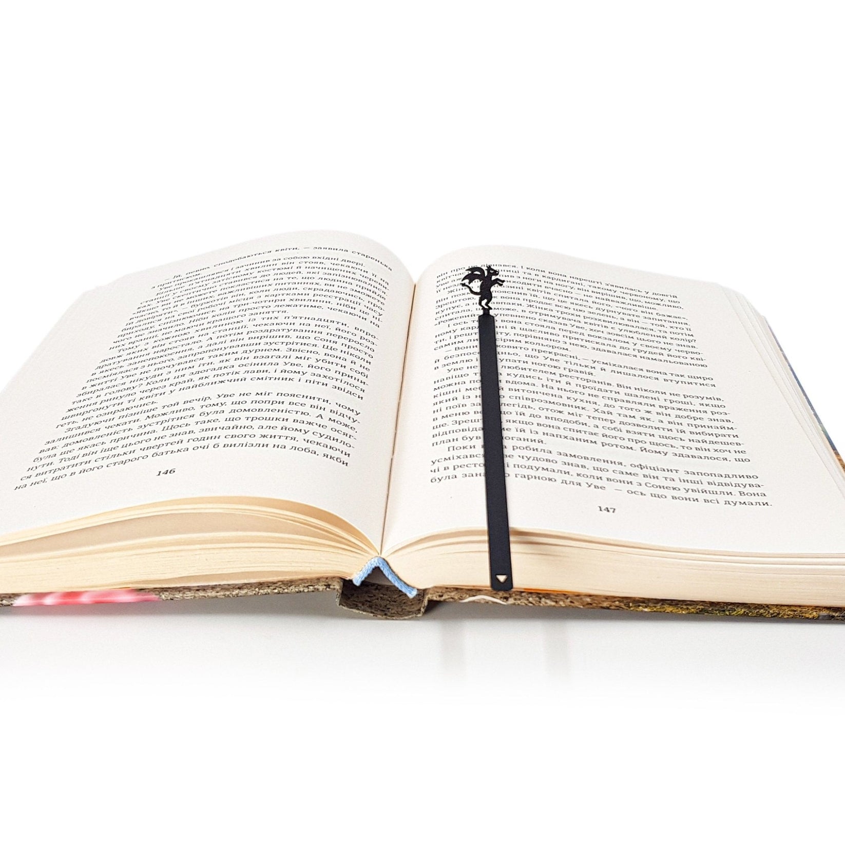 Monster Jersey Devil metal bookmark marking a page in an open book