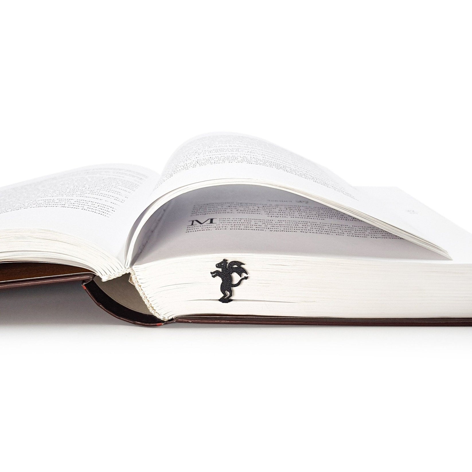 Monster Jersey Devil metal bookmark lying across the pages of an open book