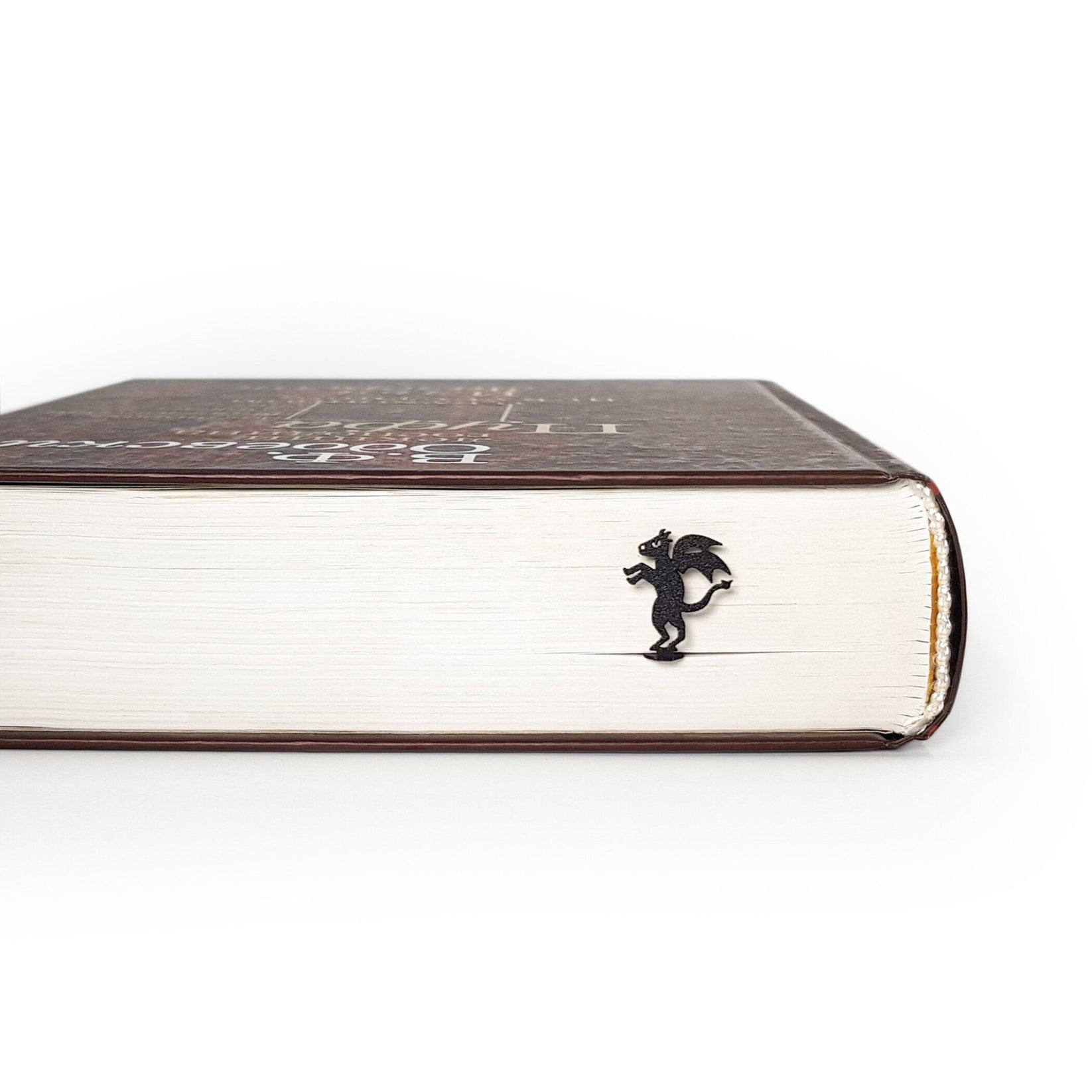 Monster Jersey Devil metal bookmark in a closed book, only its top showing above the pages