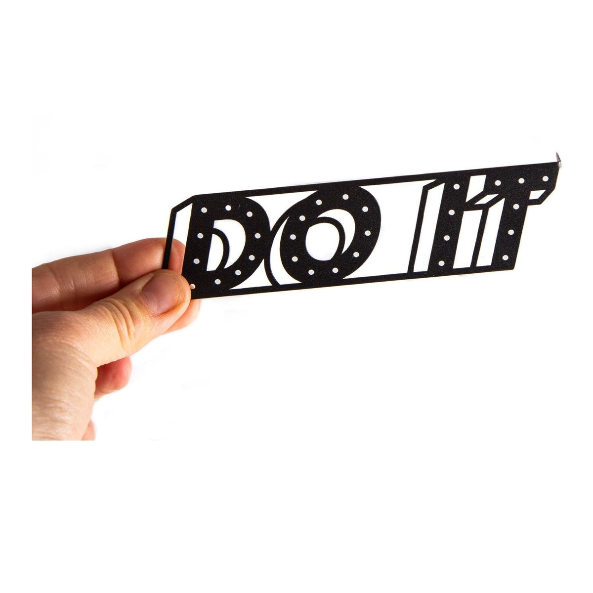 Do It metal bookmark held in a hand above an open book