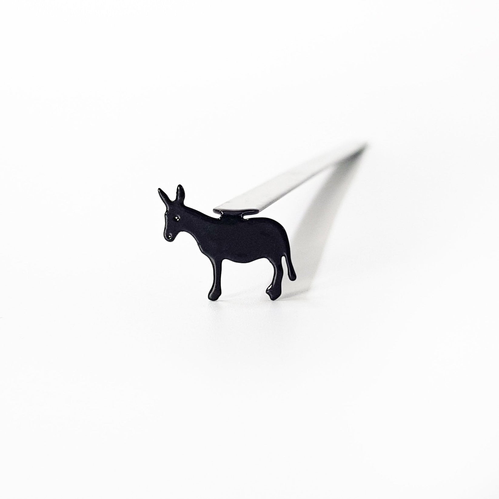 Top-down view of donkey metal bookmark inside open children's book showing scale