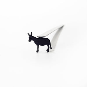 Top-down view of donkey metal bookmark inside open children's book showing scale