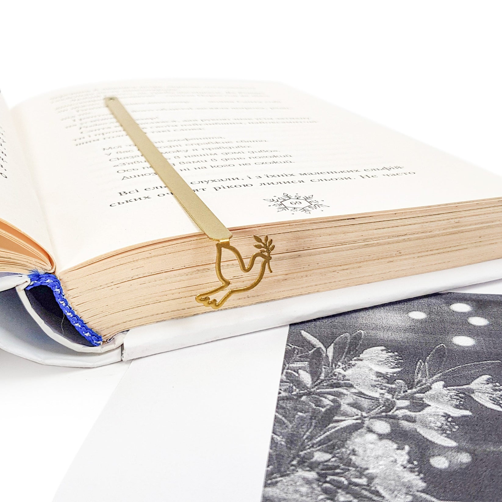 Dove of Peace metal bookmark in gold resting on the pages of an open book