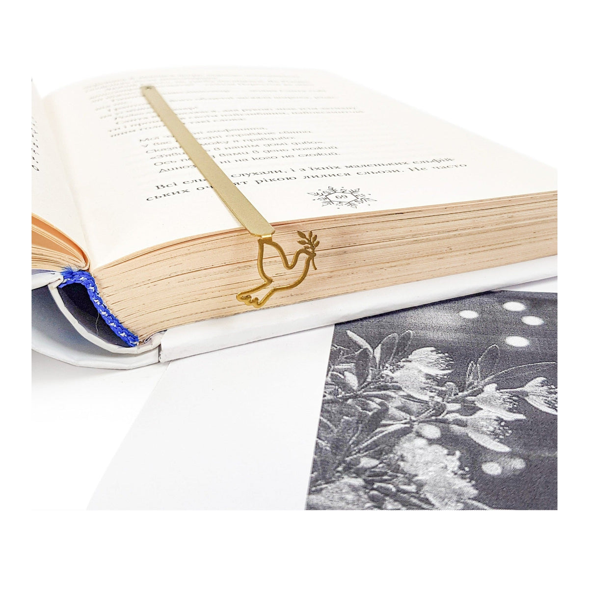 Dove of Peace metal bookmark in gold resting on the pages of an open book