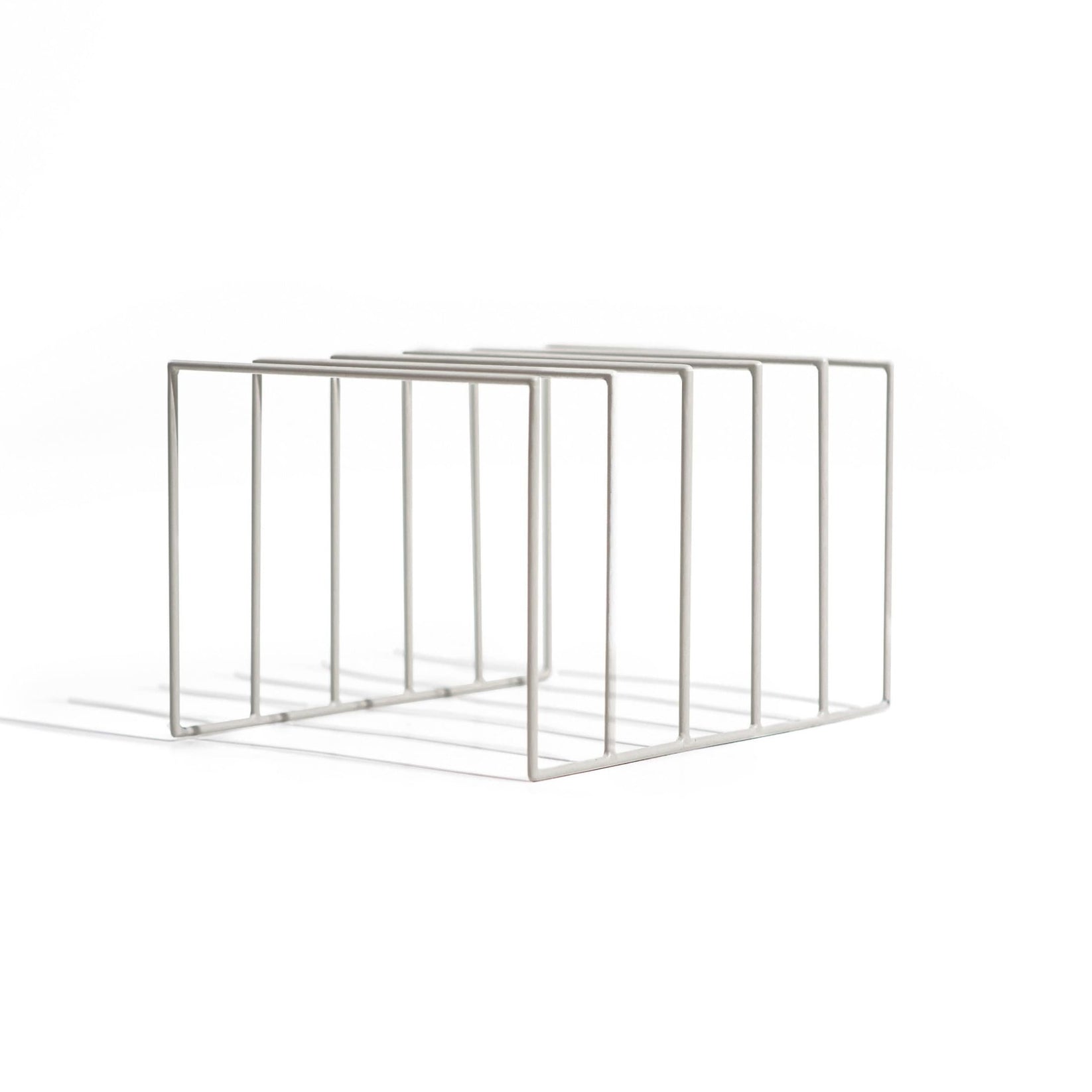 Minimalist off white metal vinyl record holder with five open slots, designed for modern interiors. The clean geometric lines and matte finish create a sleek, contemporary look against a white background.