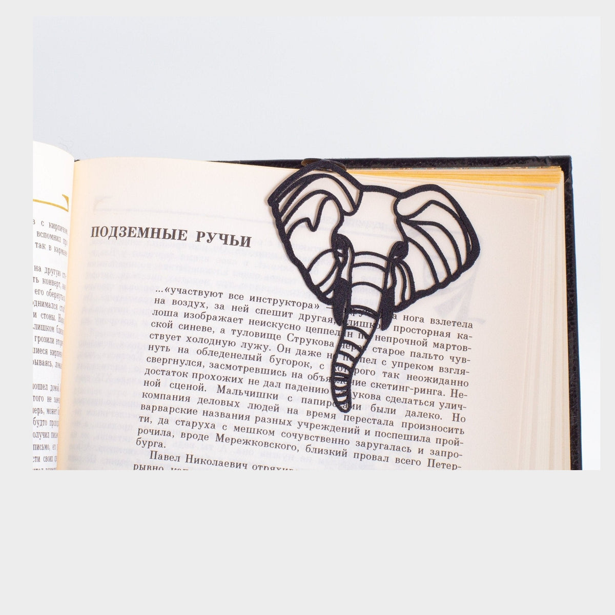 Elephant metal bookmark resting on the pages of an open book
