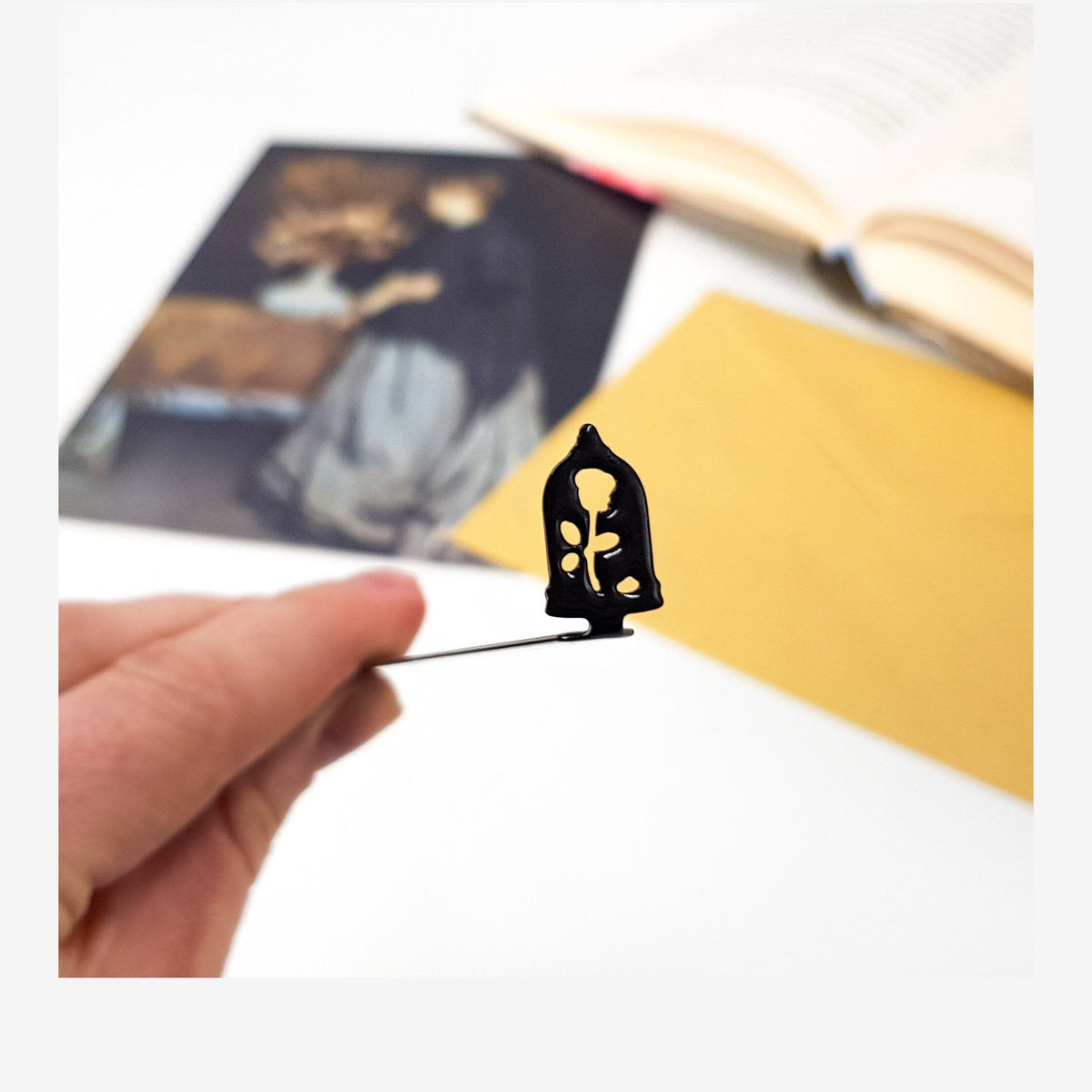 Enchanted Rose metal bookmark marking a page in an illustrated book