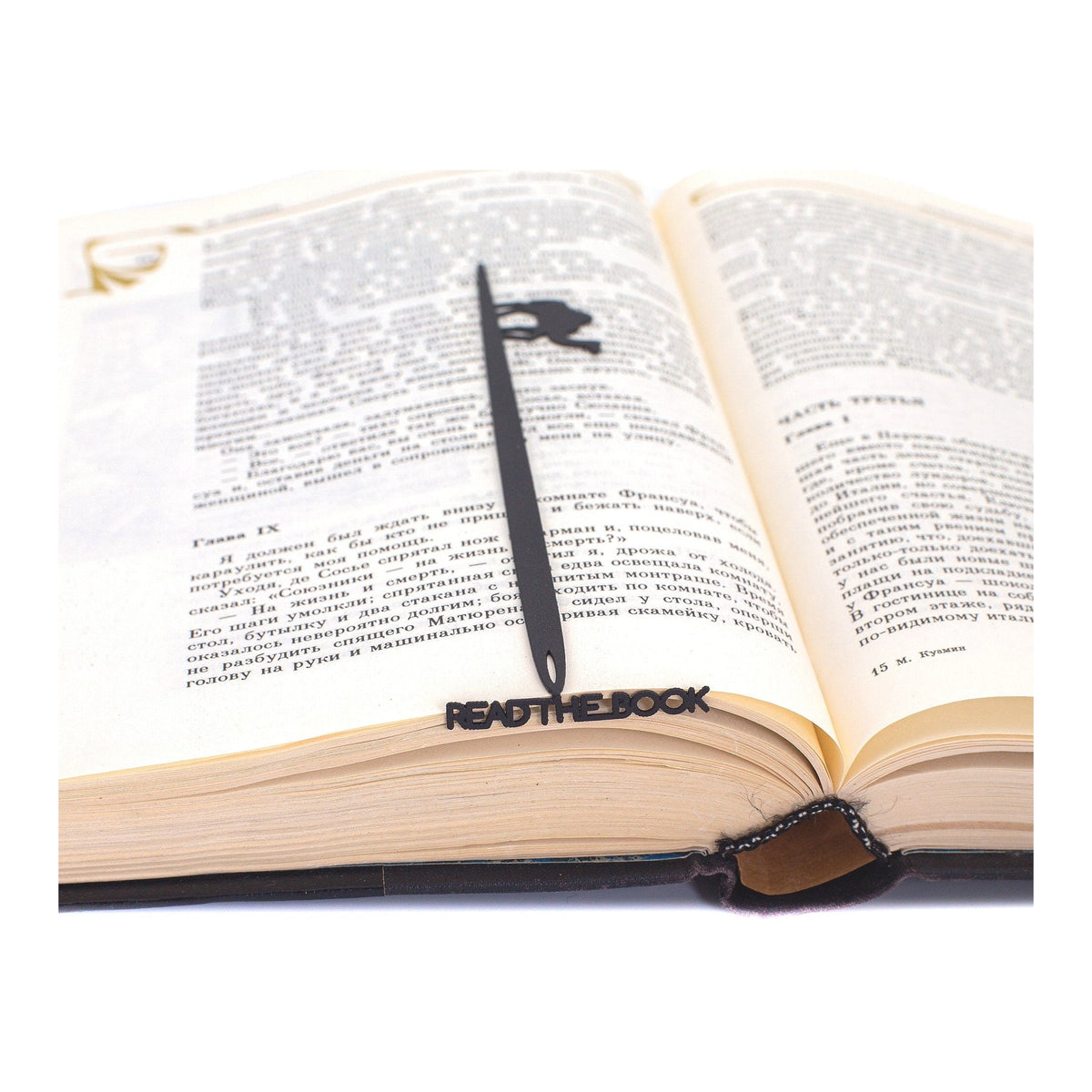 Eye of a Needle metal bookmark resting on the pages of an open book