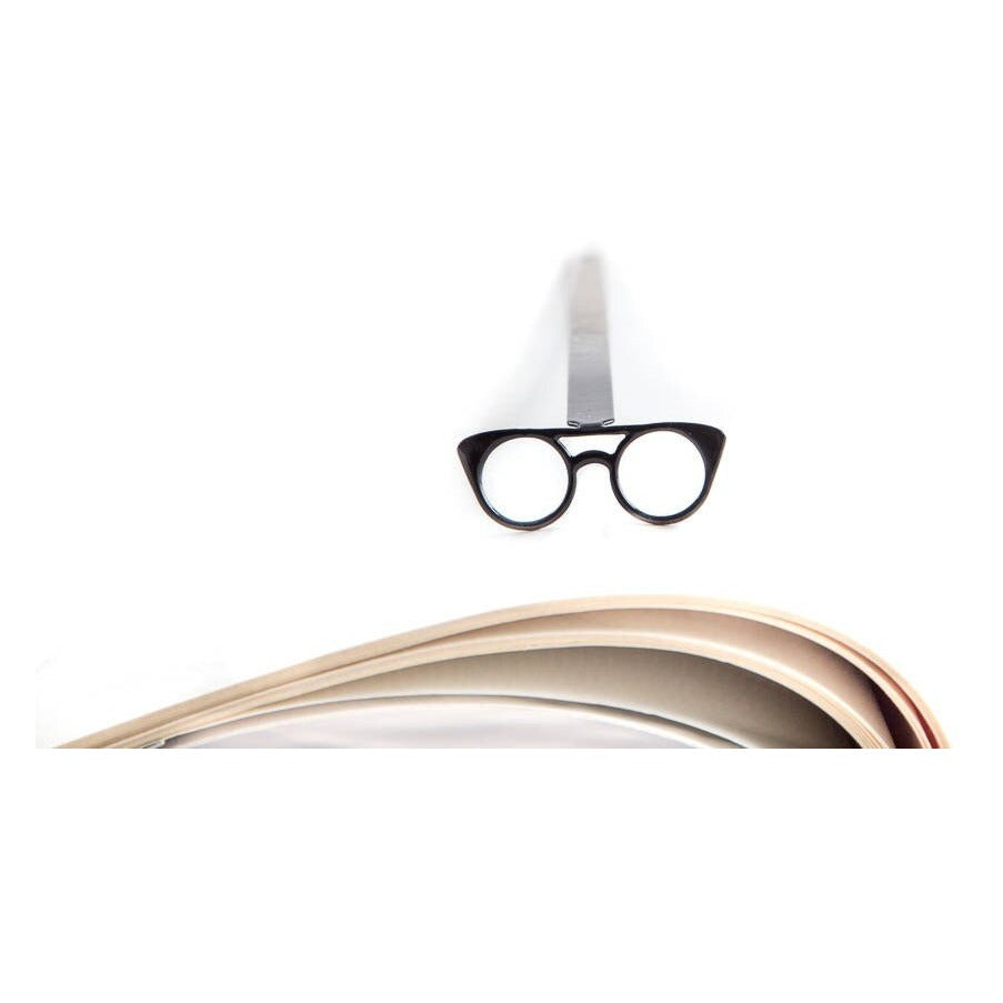 Eyeglasses metal bookmark resting on the pages of an open book