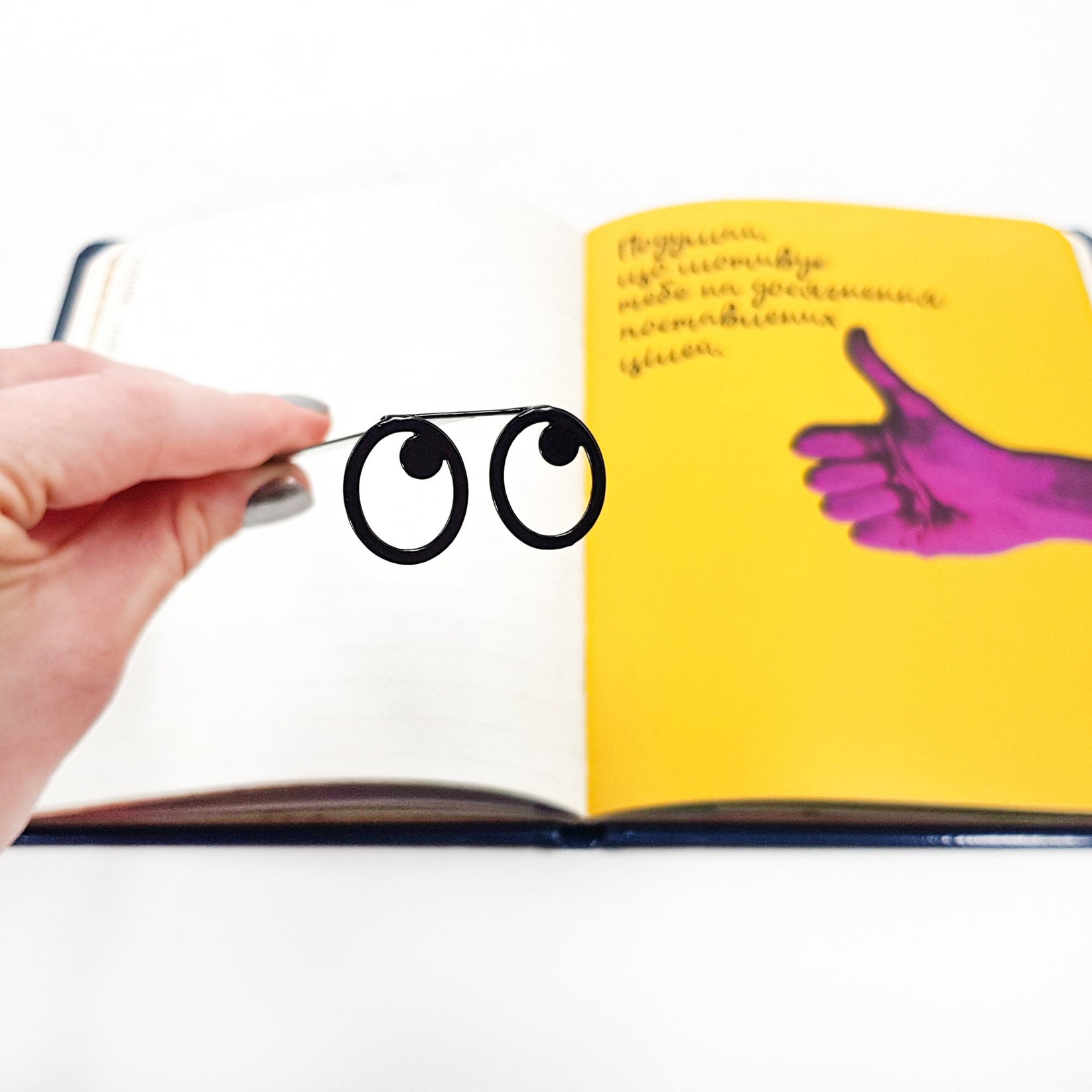 Eyes Glasses metal bookmark marking a page in an illustrated book