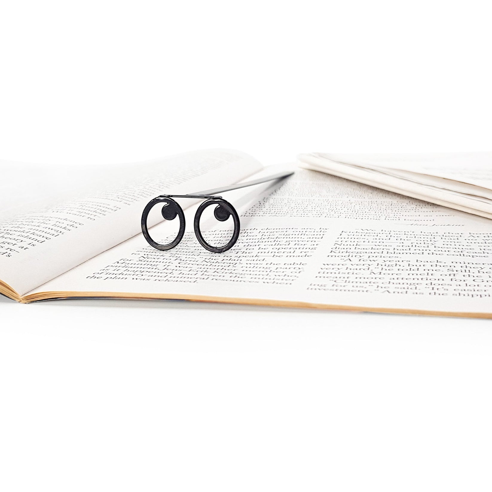 Eyes Glasses metal bookmark marking a page in an open book